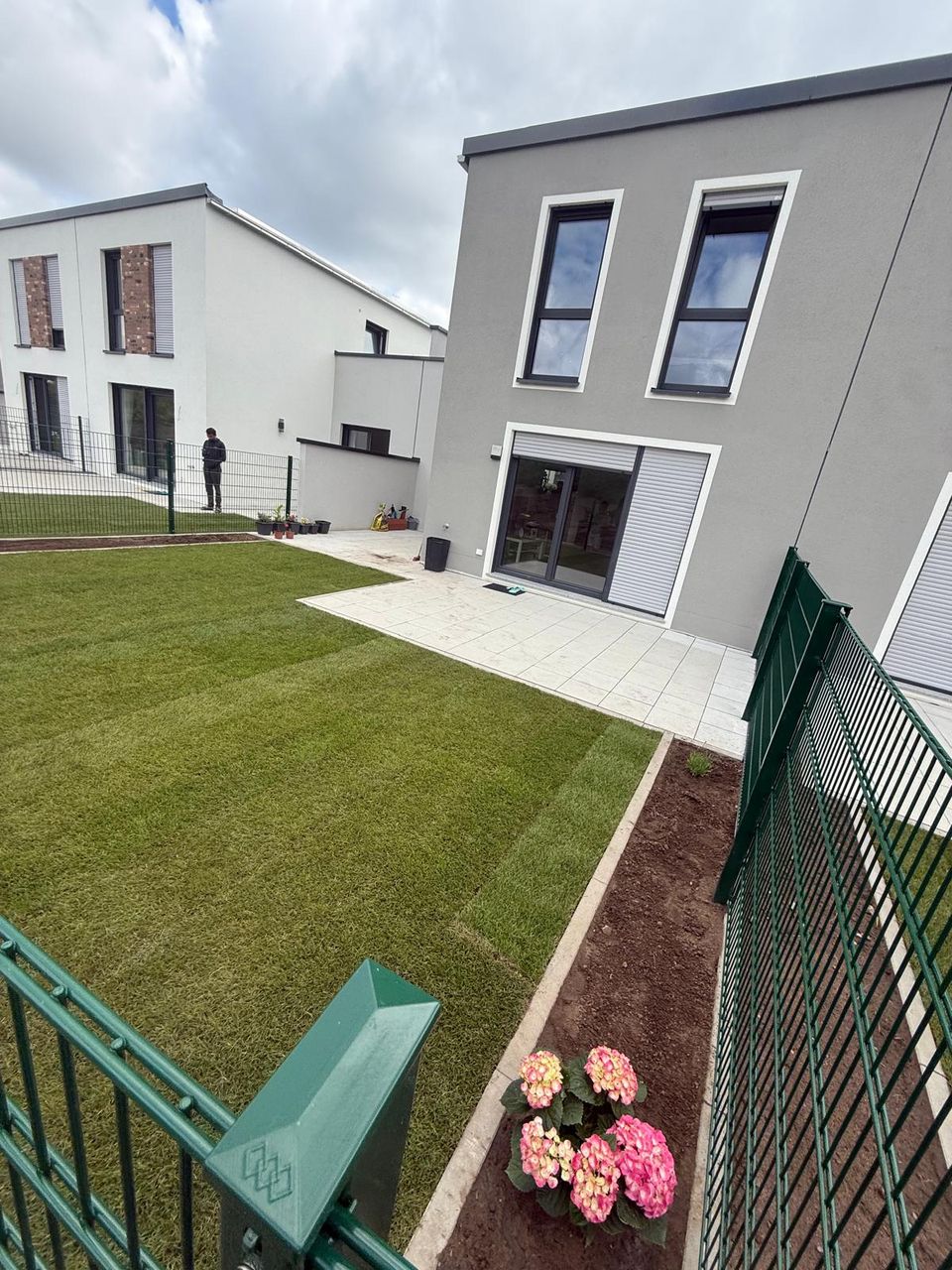 Übergang von der Terrasse zur frischen Rasenfläche