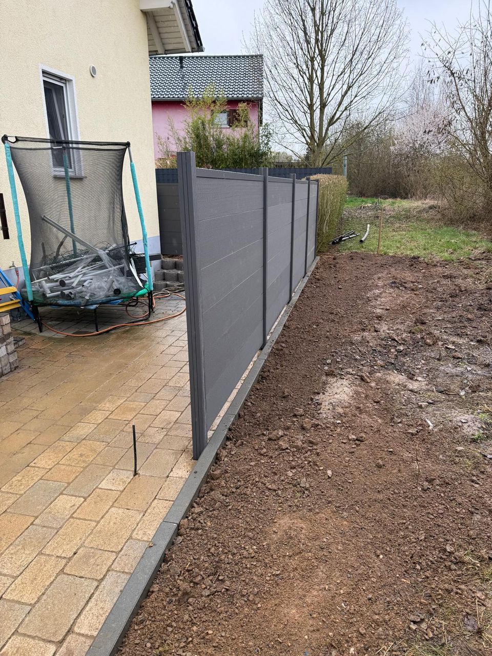 WPC-Sichtschutz in Anthrazit mit Pflasterterrasse
