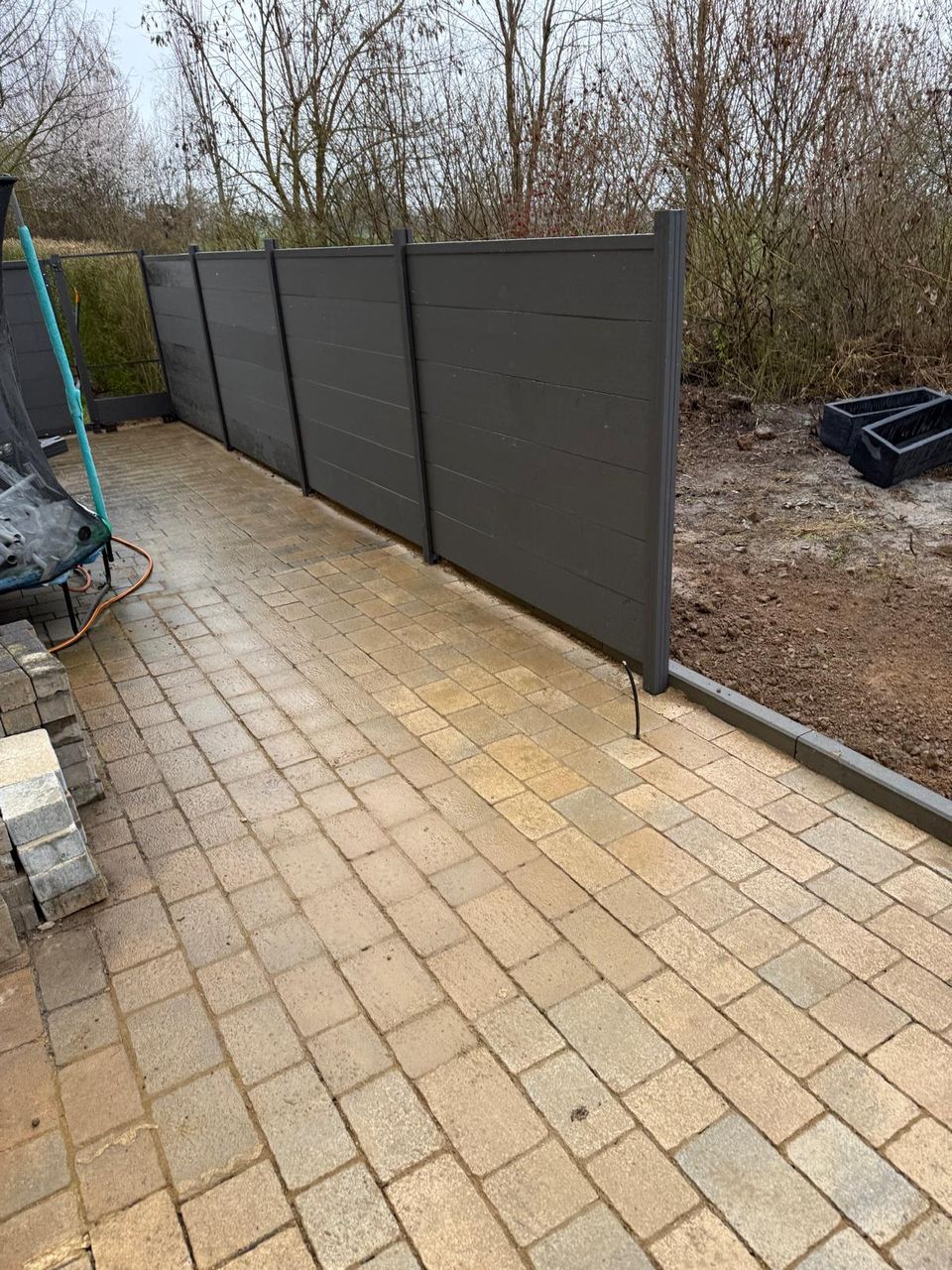 Blickdichter WPC-Sichtschutz an gepflasterter Terrasse